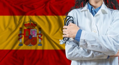 Healthcare professional with Spain flag background. Professional doctor holding stethoscope on