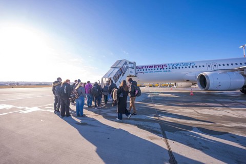 Group of travelers boards Eurowings aircraft in sunny weather, Stuttgart Airport, Germany