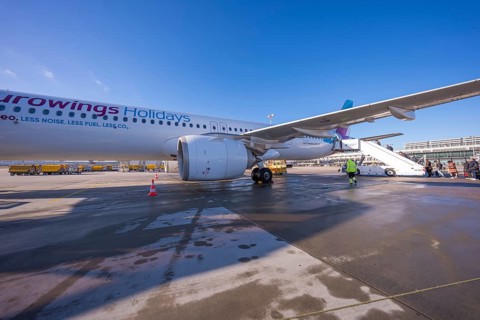 A Eurowings plane at an airport with people boarding a flight of stairs, Stuttgart Airport, Germany