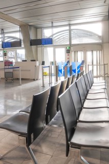 Empty waiting area at the airport with modern rows of seats and light-filled surroundings,