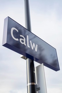 A simple town sign with the name Calw in the open air next to a street lamp, taking off the Hermann