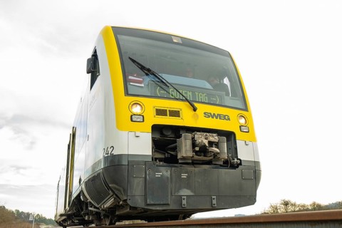 Yellow and grey SWEG vehicle on the rails against cloudy sky, taking off the Hermann Hessebahn,