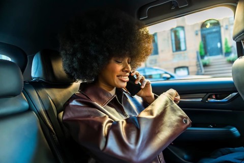 African american woman with afro hairstyle smiling while telecommunicating on a mobile phone in the