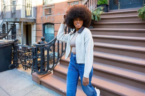 Young black woman embracing urban lifestyle while happily walking down steps of a traditional