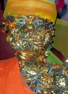 Statue of a monk in a Buddhist temple decorated with gold plates. Buddha, Buddhism, religion,
