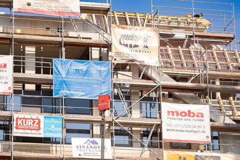 A scaffolding with various corporate advertising banners on a building, carpentry, new building,