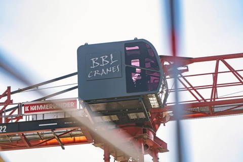 Side view of a construction crane with focus on the crane operator cabin and structures, carpentry,