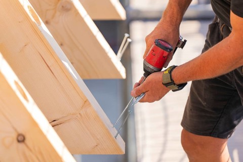 Close-up of a worker screwing a board with a drill, carpentry, new building, Stuttgart, Germany