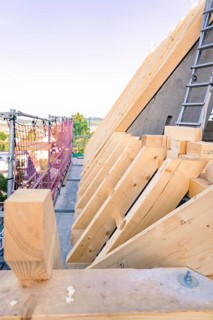 Timber structure of a roof with a view of scaffolding in daylight, carpentry, new building,