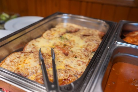 A meat dish with melted cheese in a metal mold