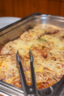 A meat dish with melted cheese in a metal mold