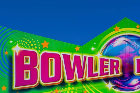 Close-up of the word Bowler painted in purple fluorescent paint on banner at Fun Show traveling