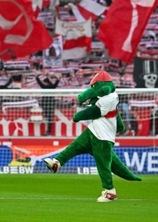 Mascot Fritzle VfB Stuttgart kicks in front of fan block, fans, fan curve, flags, atmosphere,