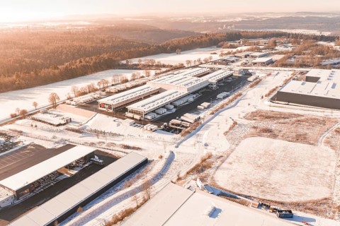 Industrial area in a wintry landscape with factory buildings, forests and snow-covered fields,
