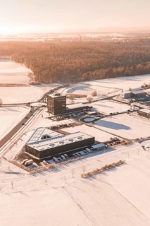 Snow-covered industrial area surrounded by extensive fields in wintry weather, Nagold, Calw