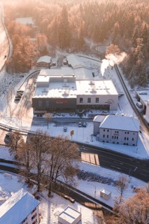Snowy factory near a forest at sunrise, steam from chimney, Nagold, Calw district, Black Forest,