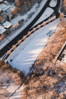 Snowy landscape with a winding road and trees casting long shadows, Nagold, Calw district, Black