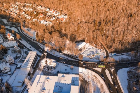 Aerial view of a snowy village surrounded by forest and roads in a wintry atmosphere, Nagold, Calw