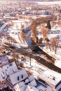Wintery cityscape with river and bridge, houses and roads covered by snow, Nagold, Calw district,