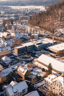 Bird's eye view of school buildings and houses in snowy winter landscape with hills, Nagold, Calw