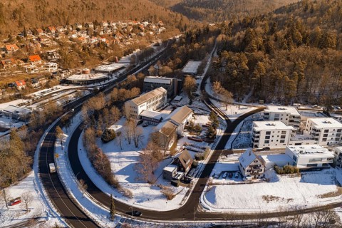 Snowy bird's-eye view of city with buildings and curved road, Nagold, Calw district, Black Forest,