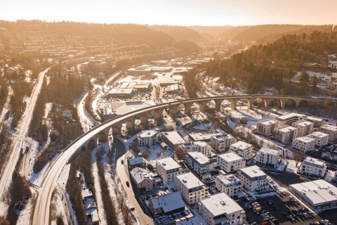 Aerial view of a viaduct and snowy cityscape surrounded by hills and roads, Nagold, Calw district,