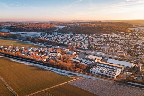 Aerial view of a settlement in winter surrounded by fields and roads, under blue sky, Althengstett,