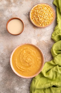 Pea cream soup, Puree, porridge in ceramic bowl on brown concrete background and green linen