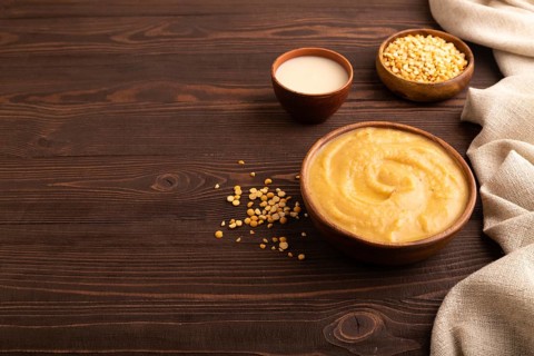 Pea cream soup, Puree, porridge in wooden bowl on wooden background and linen textile. Diet,