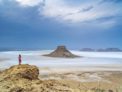 A tourist admires the inselbergs Karamaya and the Three Brothers (Three Batyrs), the Karagiye