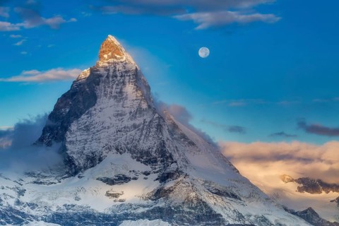 Sunrise with the moon over the Matterhorn (4, 478 m), one of the world's most iconic mountains,