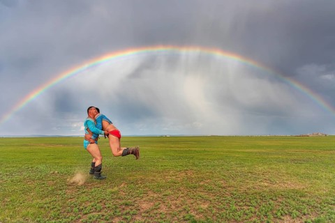 Traditional Mongolian wrestling in summer under a rainbow, Mongolia, Asia