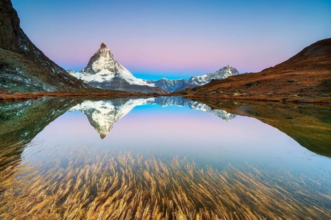 Matterhorn at 4, 478?m, iconic symbol of Switzerland, reflected in Riffelsee Lake at sunrise in