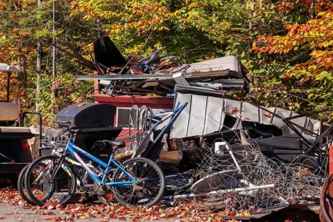 Pile of discarded metal objects including bicycles, sheet metal cladding, pipes, steel wire waiting