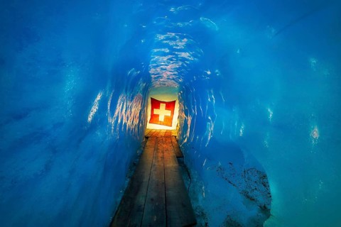 Ice cave, Swiss flag in the ice cave, Tourists attraction, Rhone glacier, Furka pass, Obergoms,