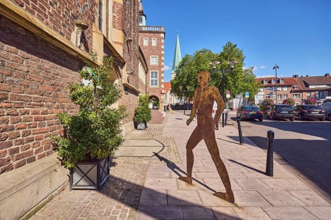 Brick building, façade, historic town hall, masonry, sculpture of a person silhouette, barrier
