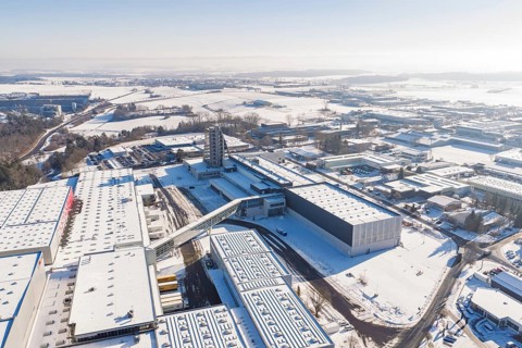 Long-range aerial view of a snow-covered industrial area with clear contours and blue sky, Häfele,