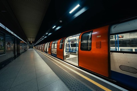 A subway train with doors open stands in the station while the lights animate the station, London,