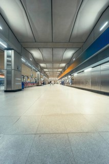 Large, empty station corridor with distinctive ceiling construction and brightness, London, United