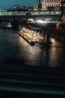 Nocturnal river landscape with illuminated bridges and buildings in the city, London, England,