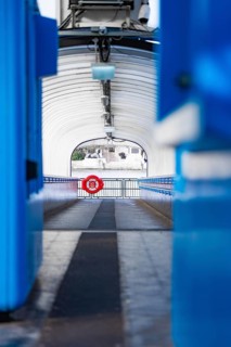 A modern, symmetrical corridor with blue elements leads outside, across boat, London, England,