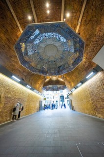 An artistically designed brick vault with lettering and people in an urban space, London Bridge