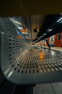 Seating area in a quiet subway station with a modern and metallic architecture, London, United