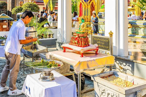The Grand Royal Palace, Wat Phra Kaeo Buddhist Temple, believers bring flowers as offerings, Phra