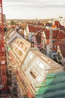 Urban construction on a roof with a crane and surrounding houses, carpentry, renovation, roof