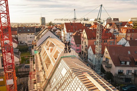 View of urban construction site in an old town with crane and roof work, carpentry, renovation,