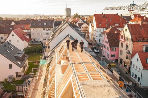 Workers on a new roof with a view of a colorful urban environment, carpentry, renovation, roof