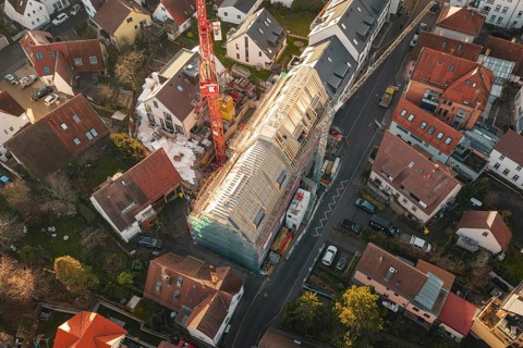 Bird's-eye view of residential area with focus on a construction site and surrounding houses,