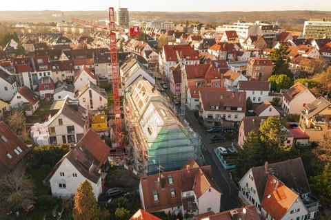 View of a city with a construction site in a residential area and surrounding countryside,
