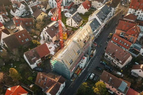 Aerial view of a construction site using cranes and roof work in an urban environment, carpentry,